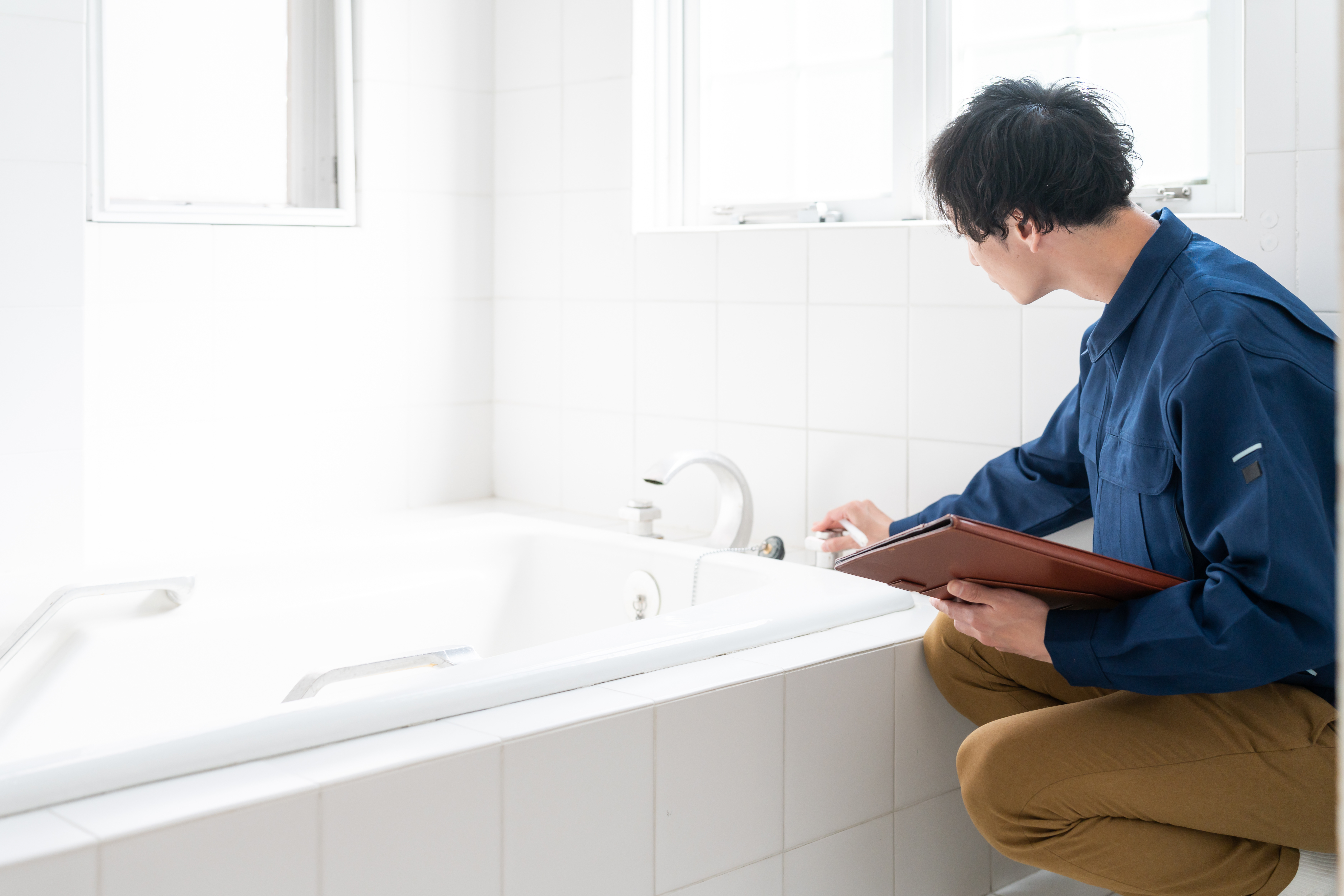 お風呂の水道を点検をする修理業者男性